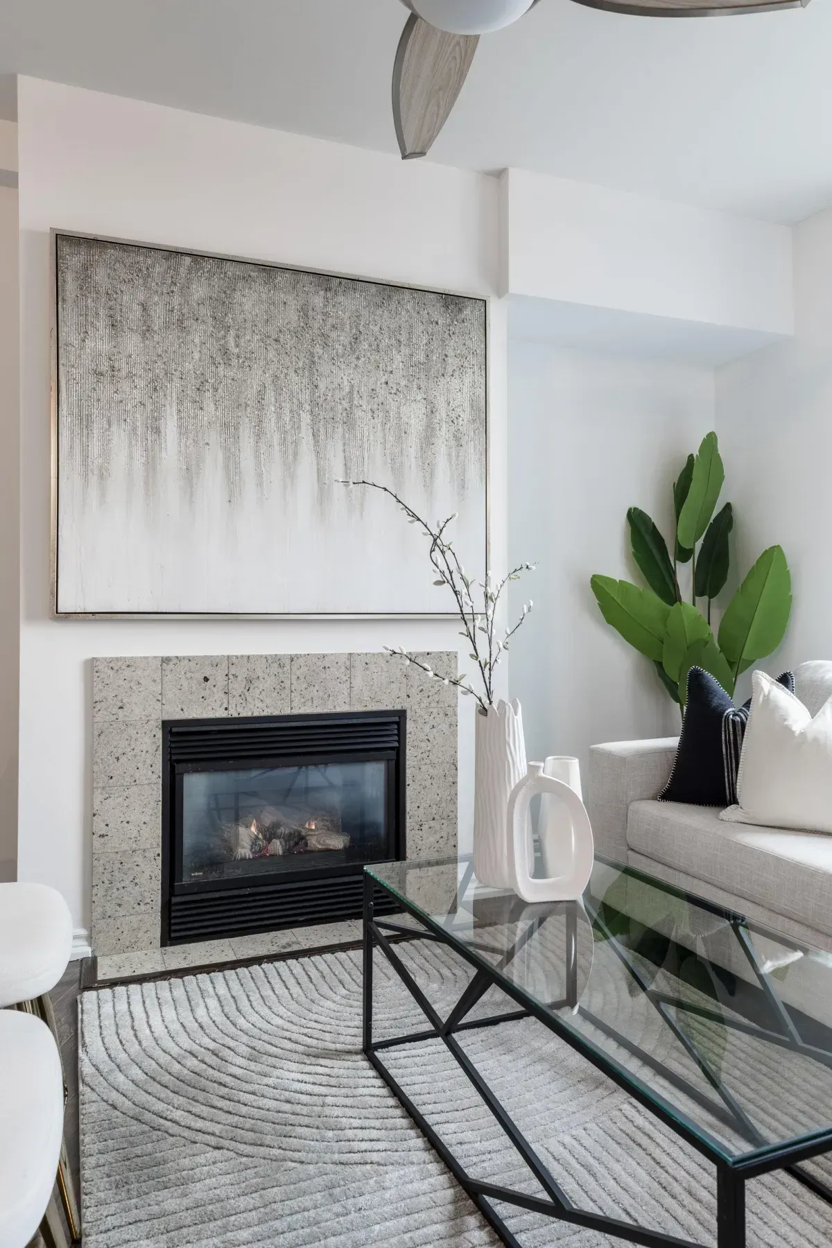 Bright living area at 5 Marine Parade Dr #630, Etobicoke, featuring a cozy gas fireplace, hardwood floors, and a ceiling fan.