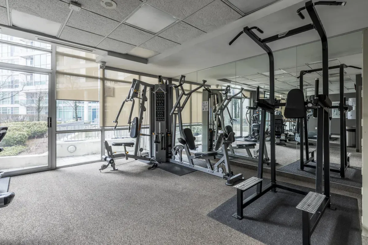 Bright, glass-walled gym at 5 Marine Parade Dr #630, Etobicoke, equipped with professional-grade cardio and strength training machines.