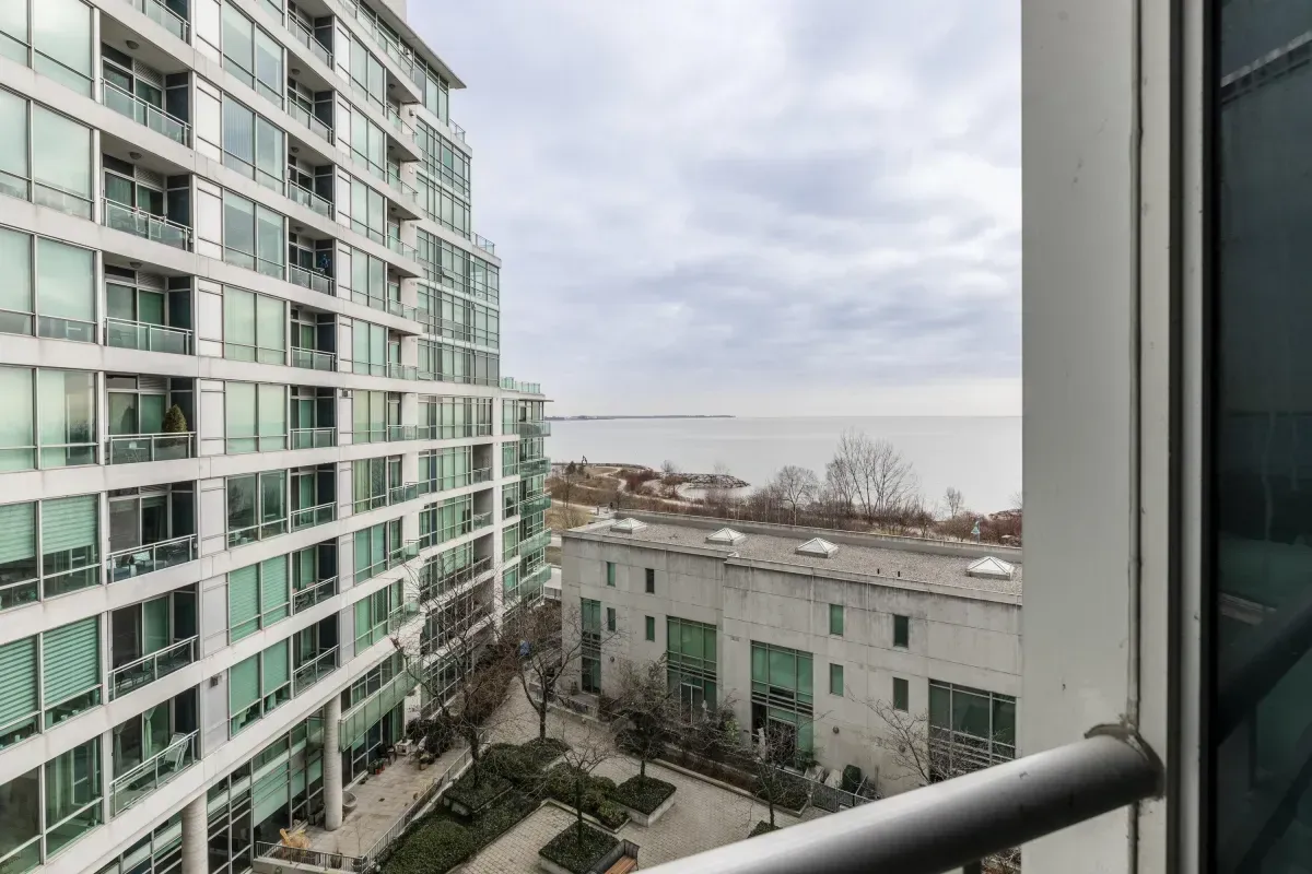 Large private balcony at 5 Marine Parade Dr #630, Etobicoke, offering a bird's-eye view of the landscaped courtyard and Lake Ontario.