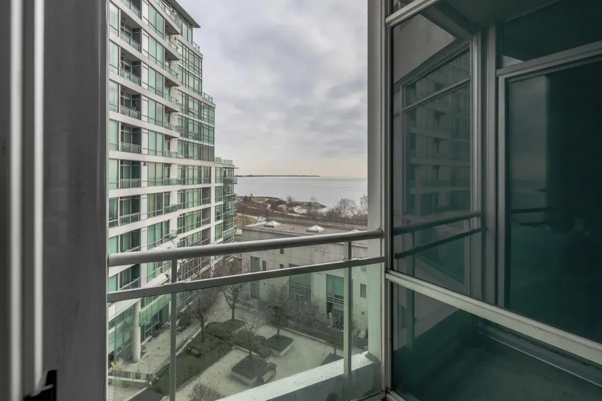 Large private balcony at 5 Marine Parade Dr #630, Etobicoke, offering a bird's-eye view of the landscaped courtyard and Lake Ontario.