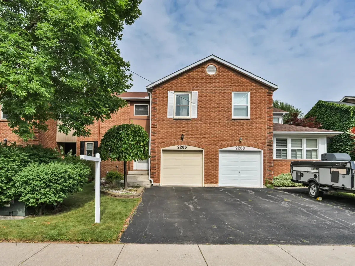 Modern red brick row townhouse with an attached garage and private driveway at 2286 Margot St, Oakville.