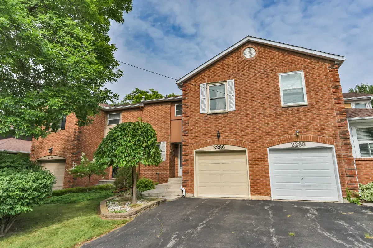 Modern red brick row townhouse with an attached garage and private driveway at 2286 Margot St, Oakville.