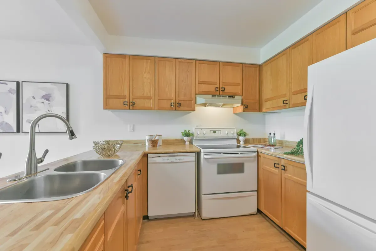 Functional kitchen with wood cabinetry, updated appliances, and a breakfast bar at 2286 Margot St, Oakville.