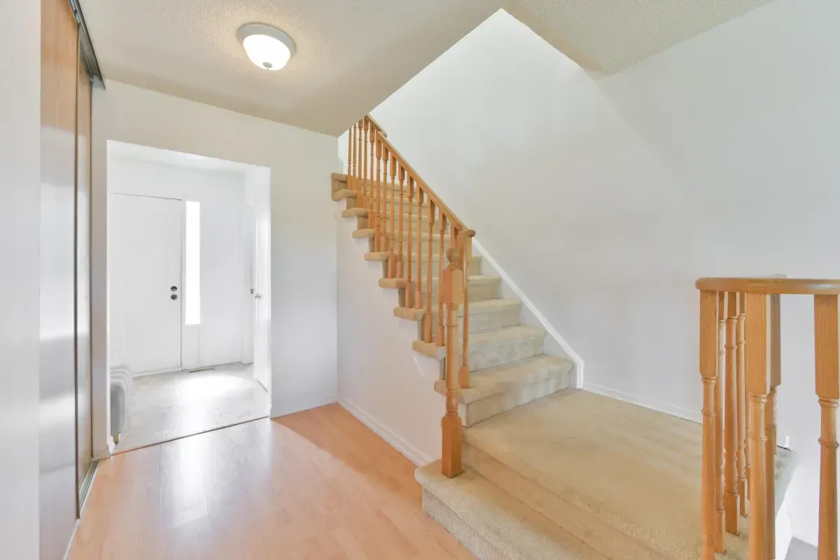 Well-maintained wooden stairs at 2286 Margot St, Oakville, featuring a wide landing and neutral-toned walls.