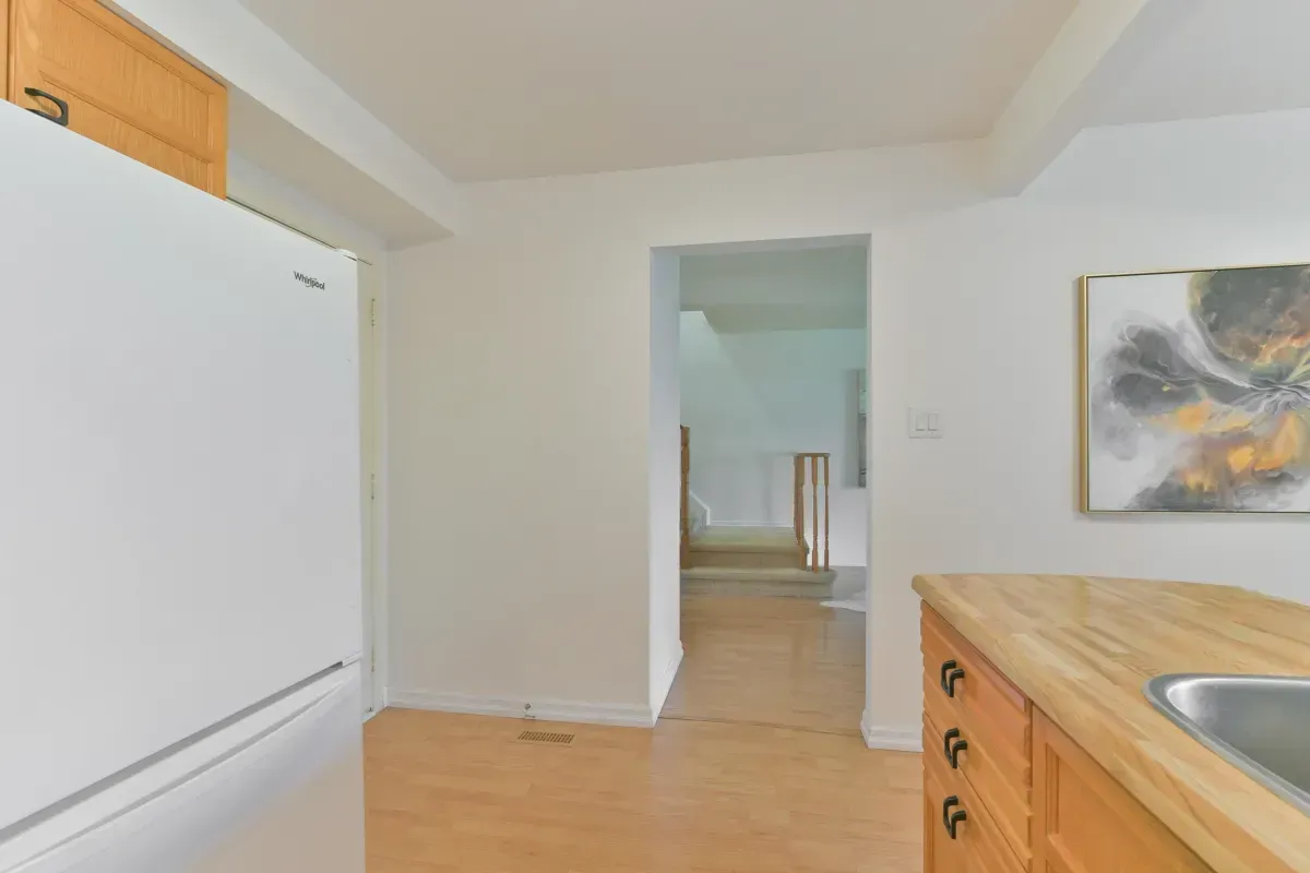 Functional kitchen with wood cabinetry, updated appliances, and a breakfast bar at 2286 Margot St, Oakville.