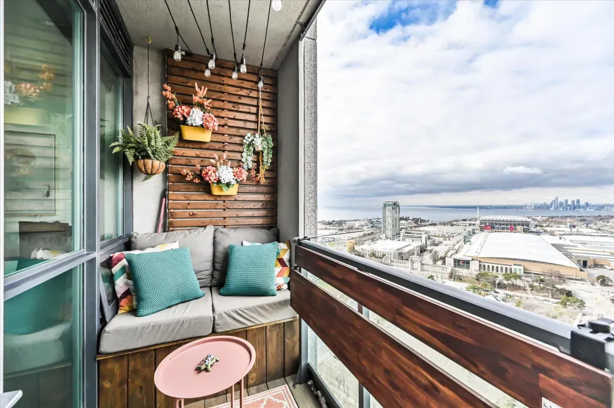 Cozy outdoor balcony with wood accents and seating overlooking Toronto’s waterfront.