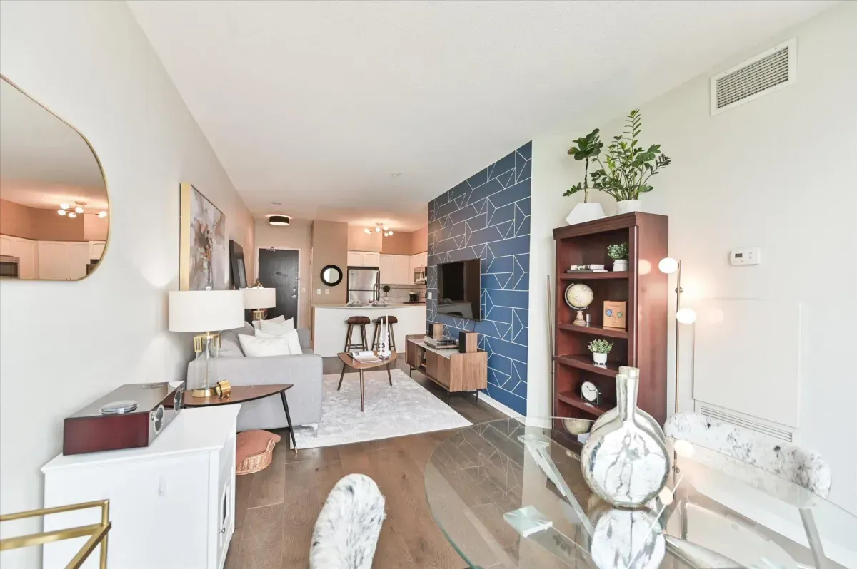 Open-concept living room at 219 Fort York Blvd featuring a blue accent wall and floor-to-ceiling windows.