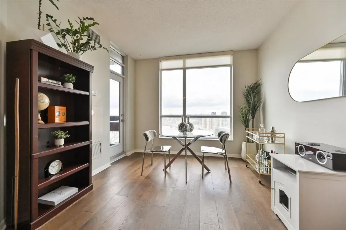 Modern open-concept dining area at 219 Fort York Blvd #3301 with glass table and hardwood floors.