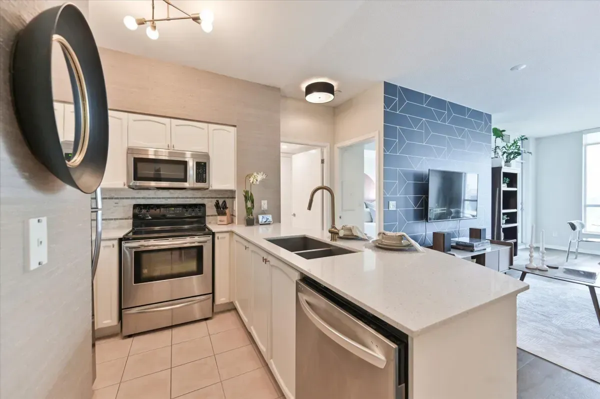 Modern kitchen island with double sink and breakfast bar seating in unit 3301.