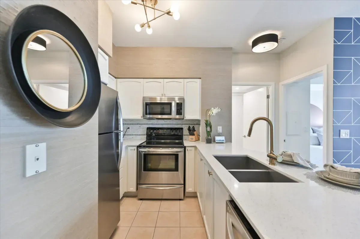 Modern kitchen island with double sink and breakfast bar seating in unit 3301.