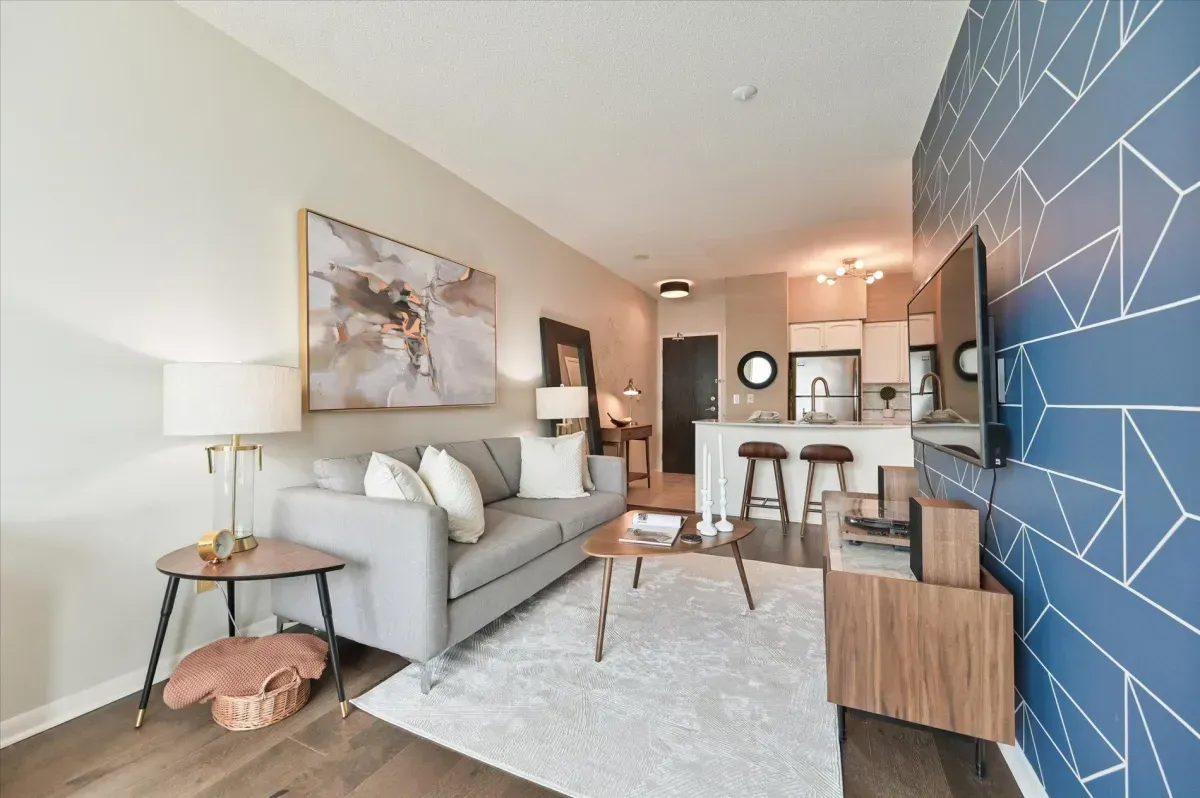 Open-concept living room at 219 Fort York Blvd featuring a blue accent wall and floor-to-ceiling windows.