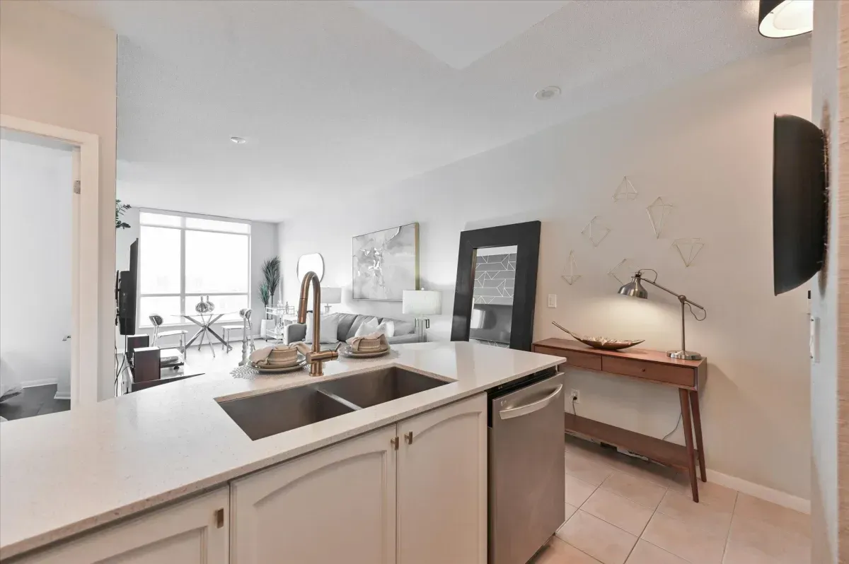 Modern kitchen island with double sink and breakfast bar seating in unit 3301.