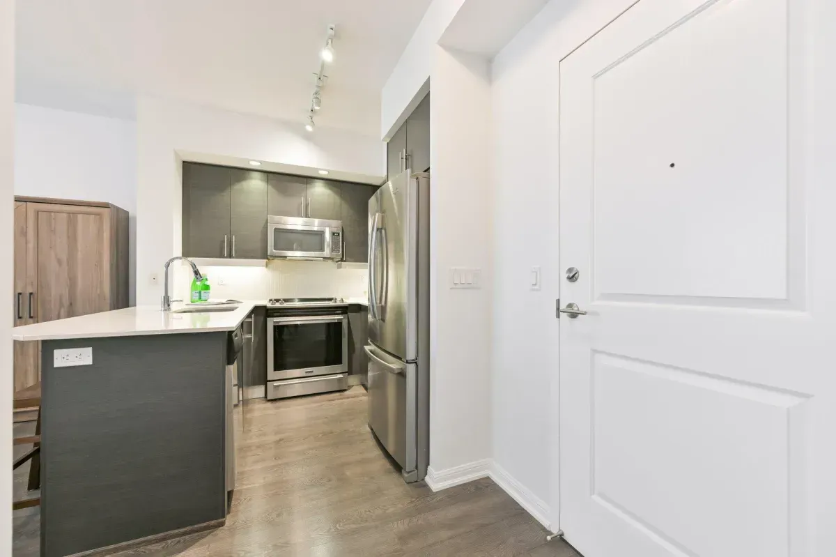 Modern kitchen at 85 E Liberty St #1909 featuring granite countertops, stainless steel appliances, and a social breakfast bar.