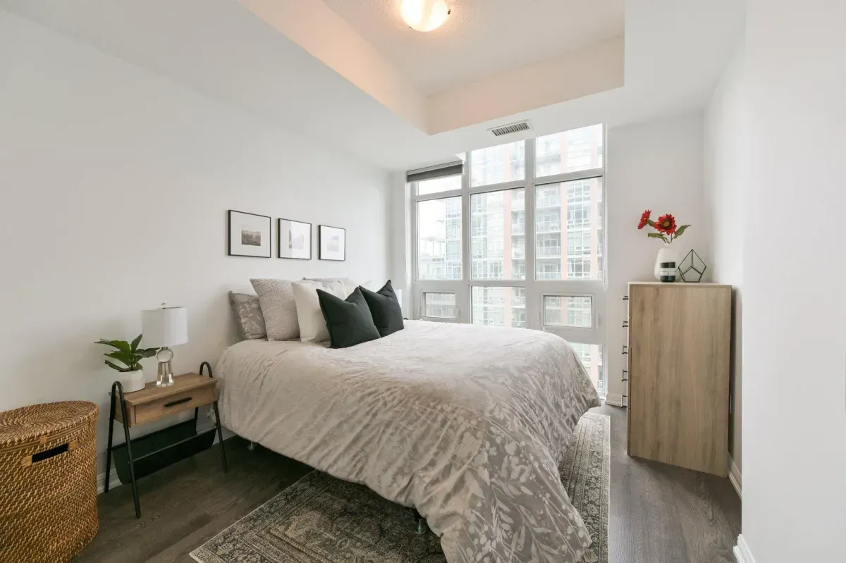 Spacious 1-bedroom suite with neutral decor and large windows overlooking downtown Toronto.
