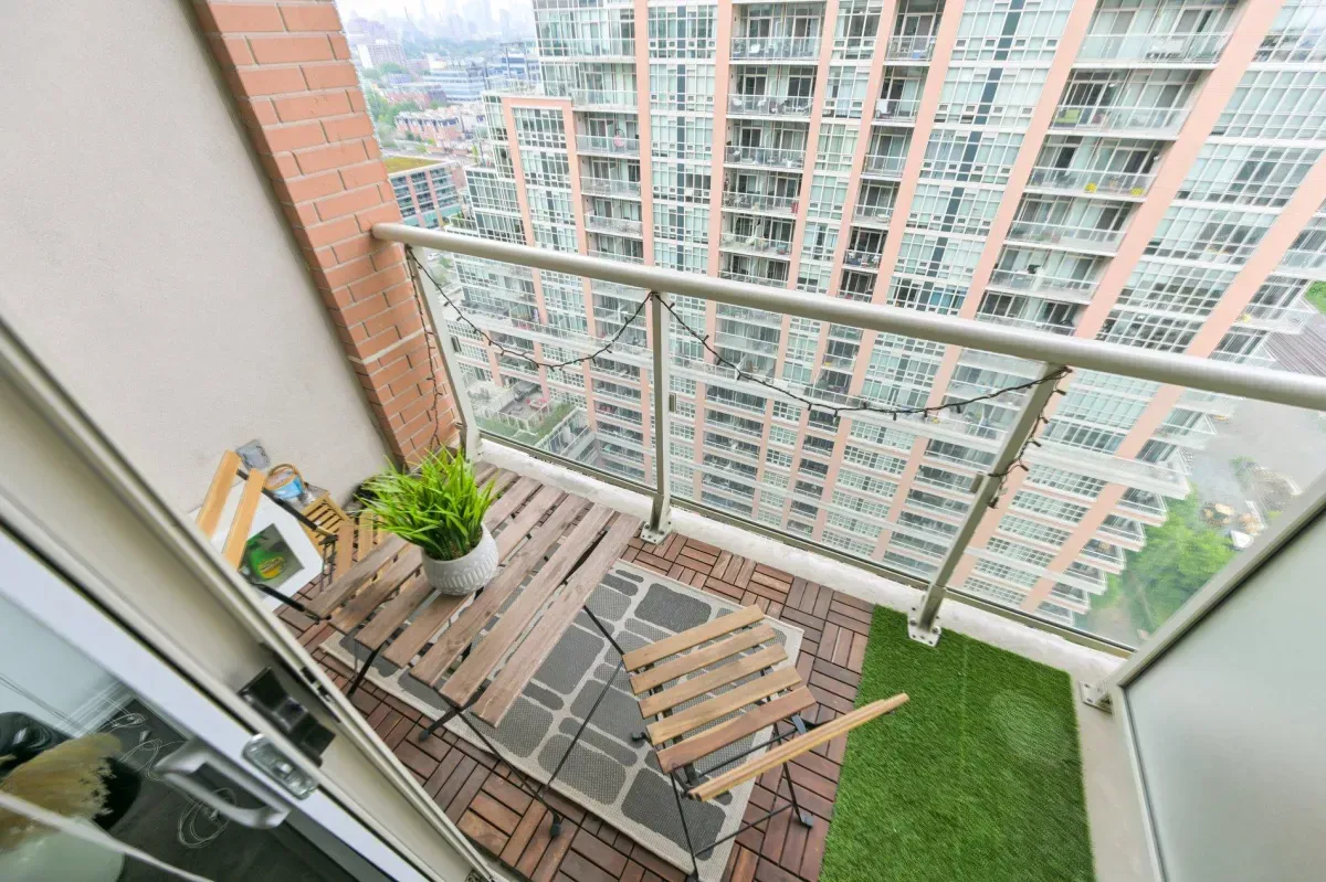 Wood-decked private balcony at 85 E Liberty St #1909 with glass railings and city views.