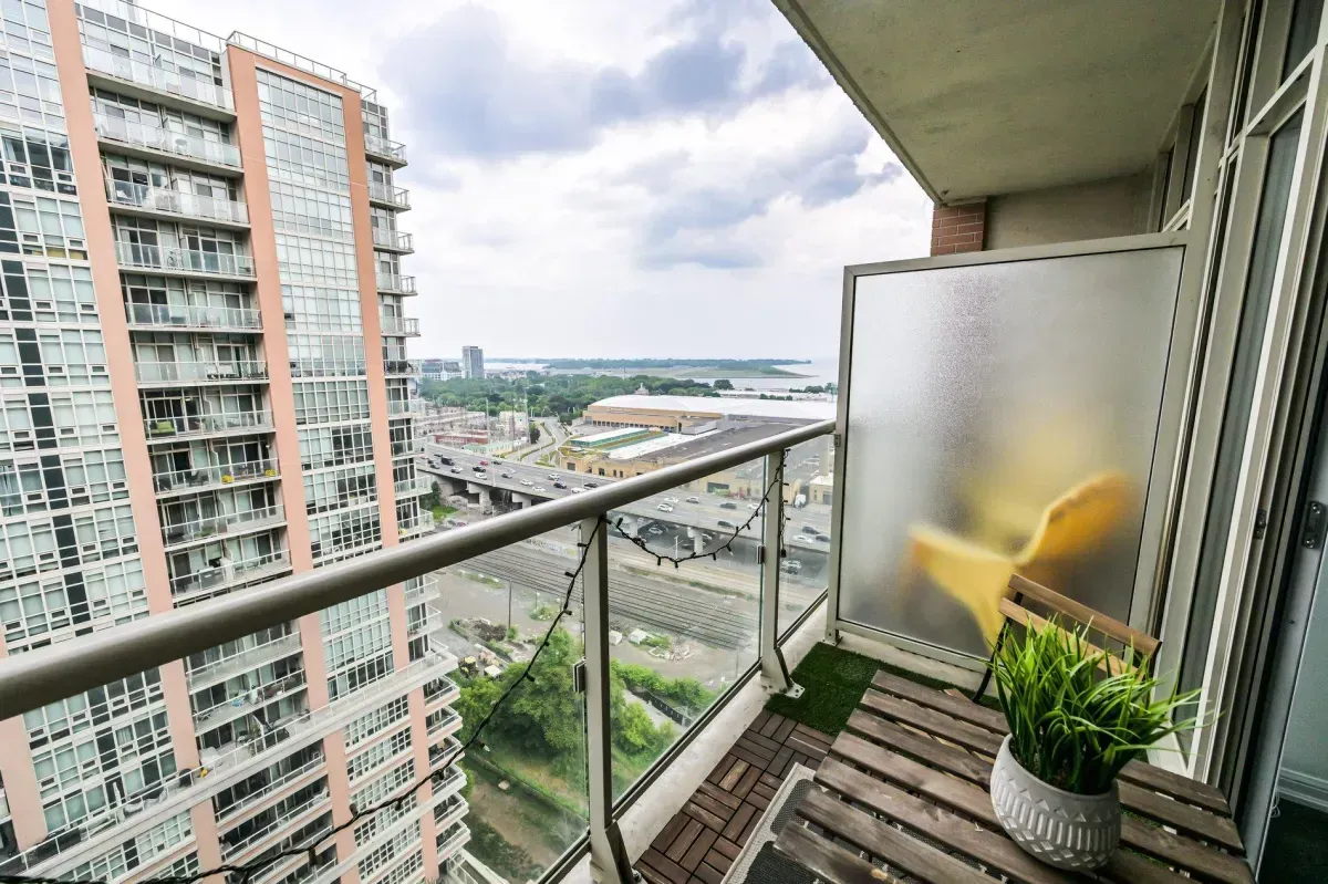 Wood-decked private balcony at 85 E Liberty St #1909 with glass railings and city views.