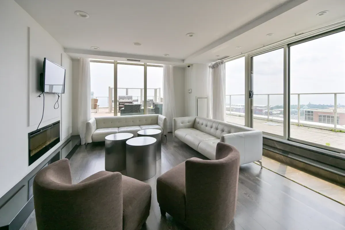 High-floor resident lounge at 85 E Liberty St #1909 building featuring a fireplace, panoramic windows, and walk-out terrace.