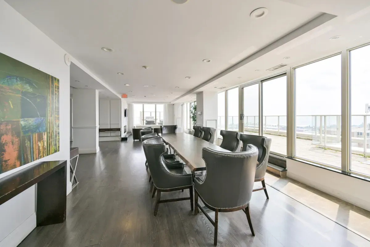Sophisticated resident dining room and boardroom with floor-to-ceiling windows and city views at 85 E Liberty St.