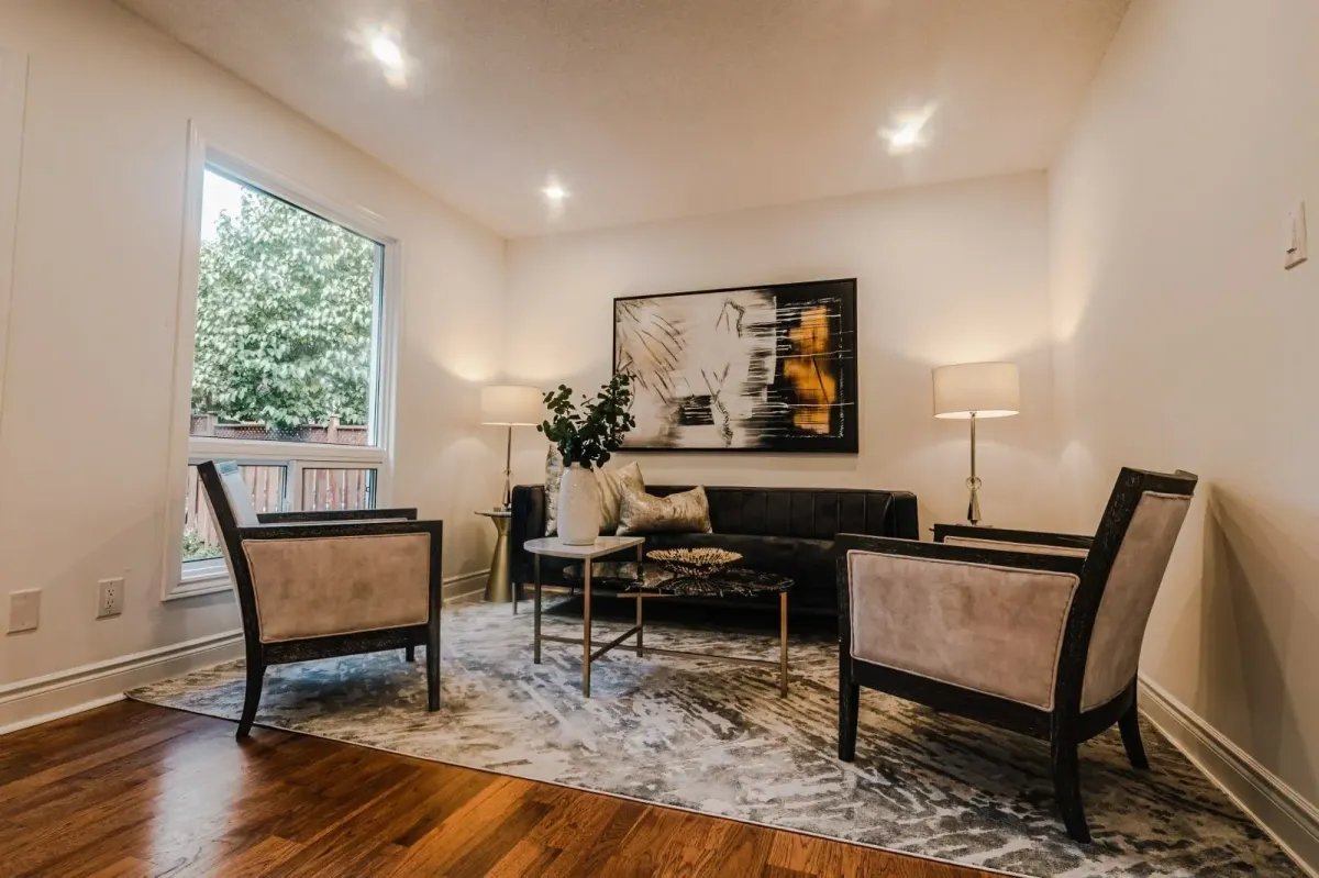 Bright living room at 110 Holliday Dr with hardwood floors, neutral styling, and a large window overlooking the front yard.