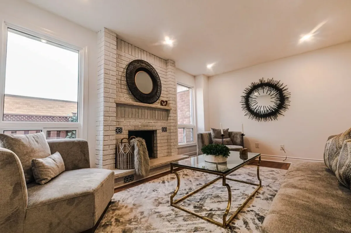 Cozy family room at 110 Holliday Dr featuring a white painted brick fireplace with a wood mantel and circular mirror.