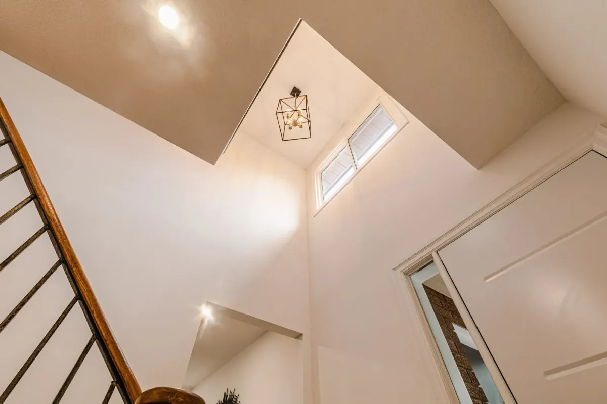 Grand foyer at 110 Holliday Dr featuring high ceilings, a hanging light fixture, and a wood staircase.