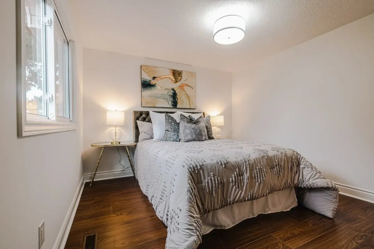 Second bedroom at 110 Holliday Dr with hardwood floors, a large window, and modern staging.