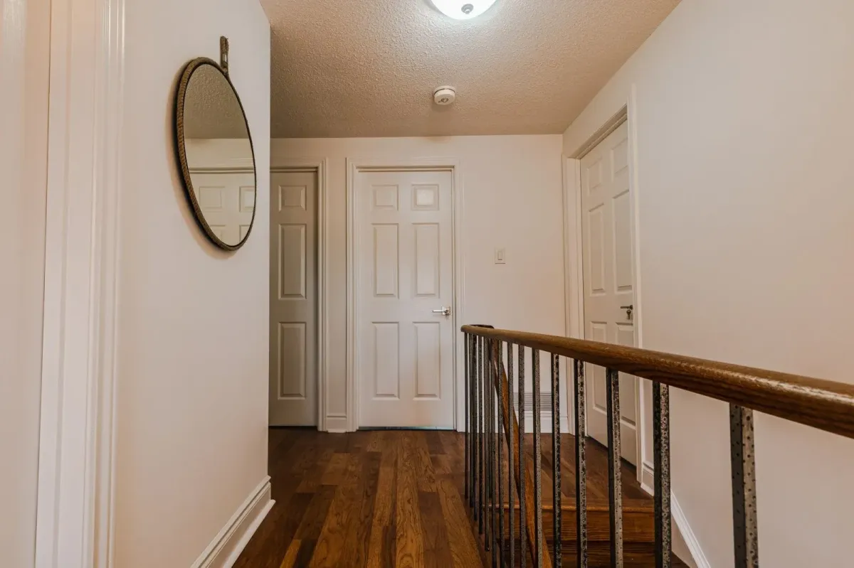 Second-floor hallway at 110 Holliday Dr with hardwood floors and wood railings.