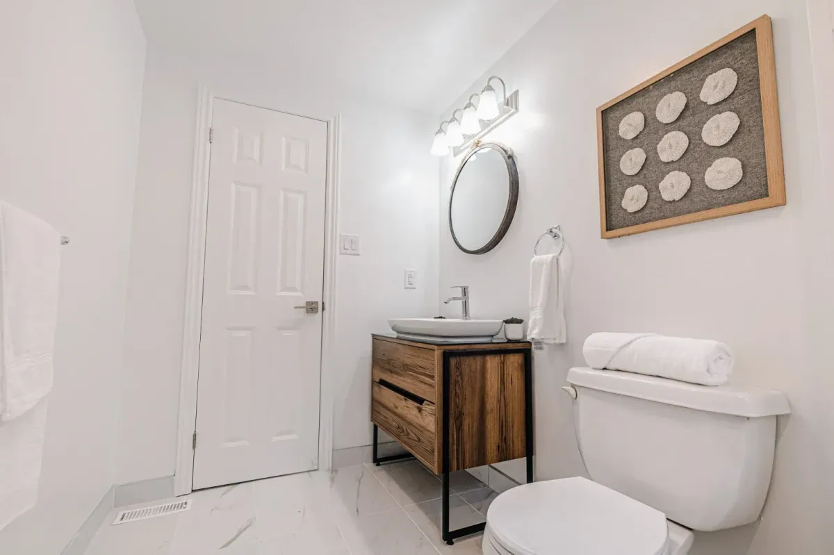 Fully renovated basement bathroom at 110 Holliday Dr with a modern wood vanity and updated fixtures.