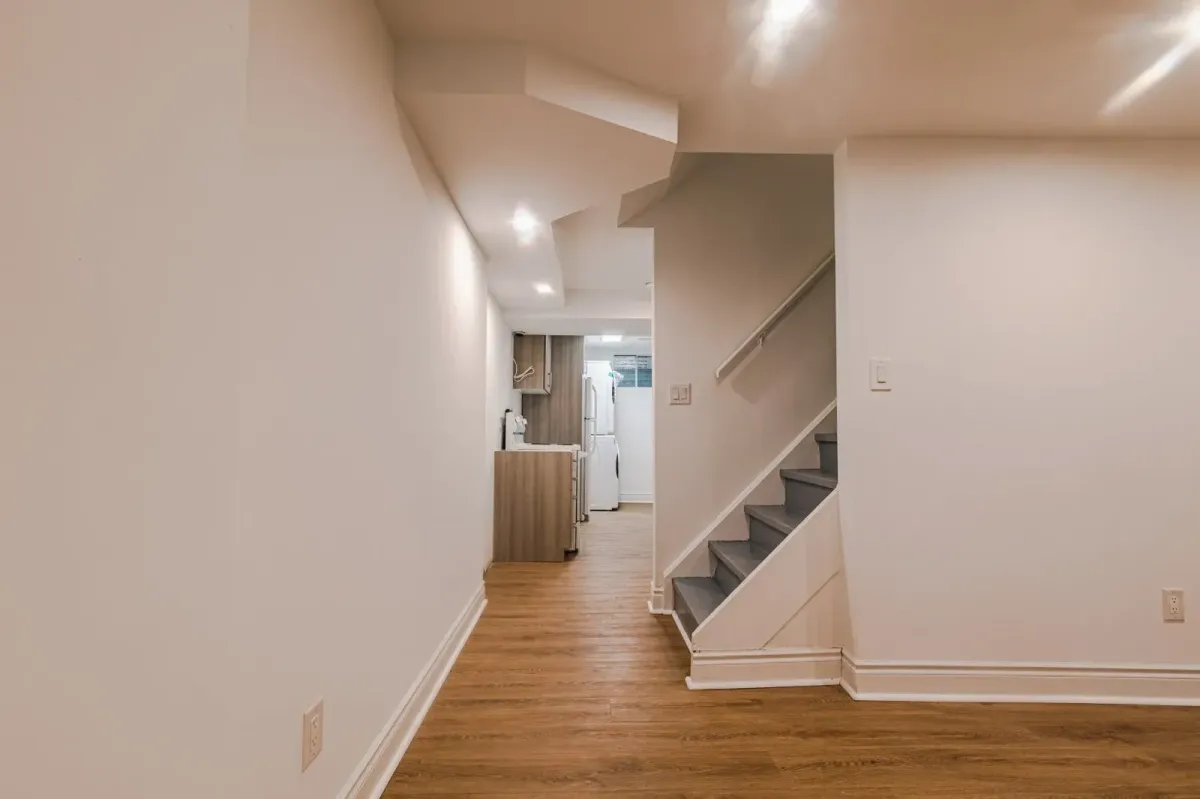 Wide-angle view of the light-filled, finished basement recreation area at 110 Holliday Dr.