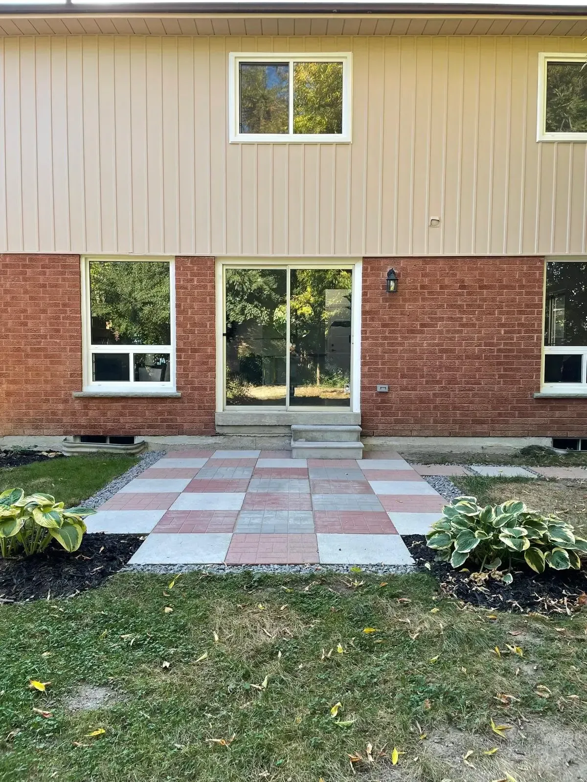 Back view of 110 Holliday Dr highlighting the patio and sliding door entrance.