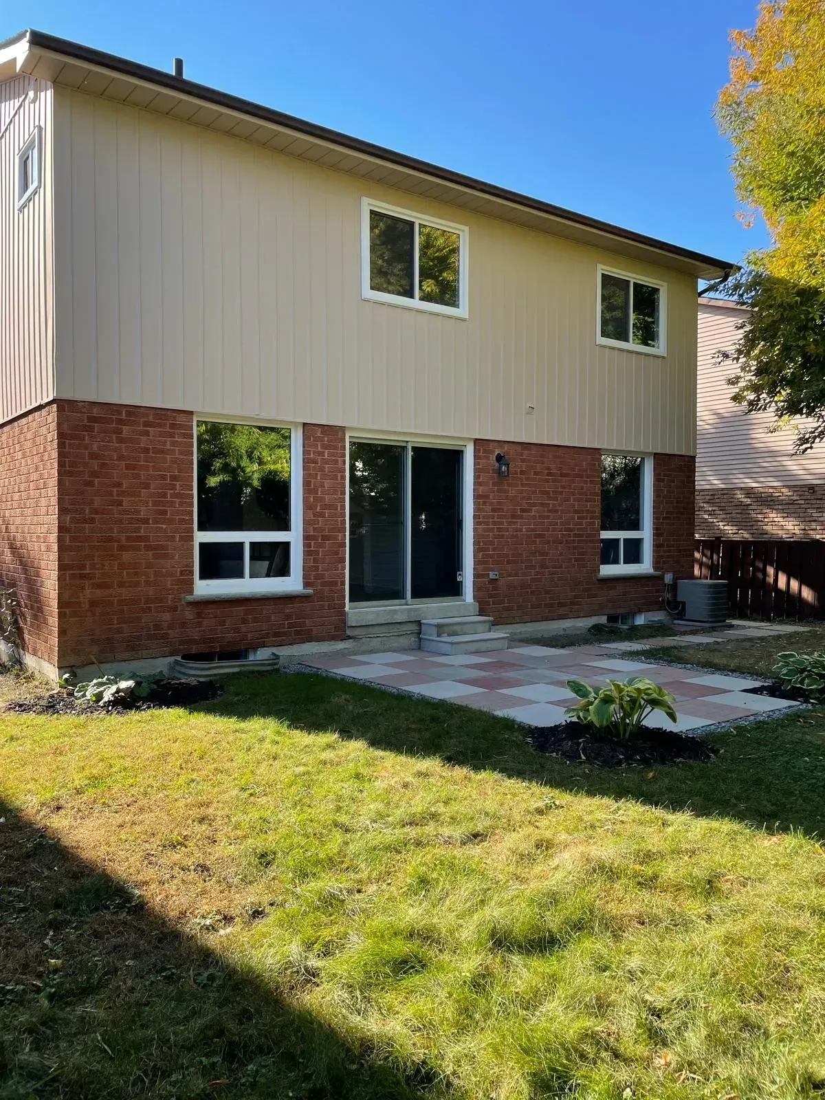 Rear exterior of 110 Holliday Dr showing the two-story brick and siding construction.