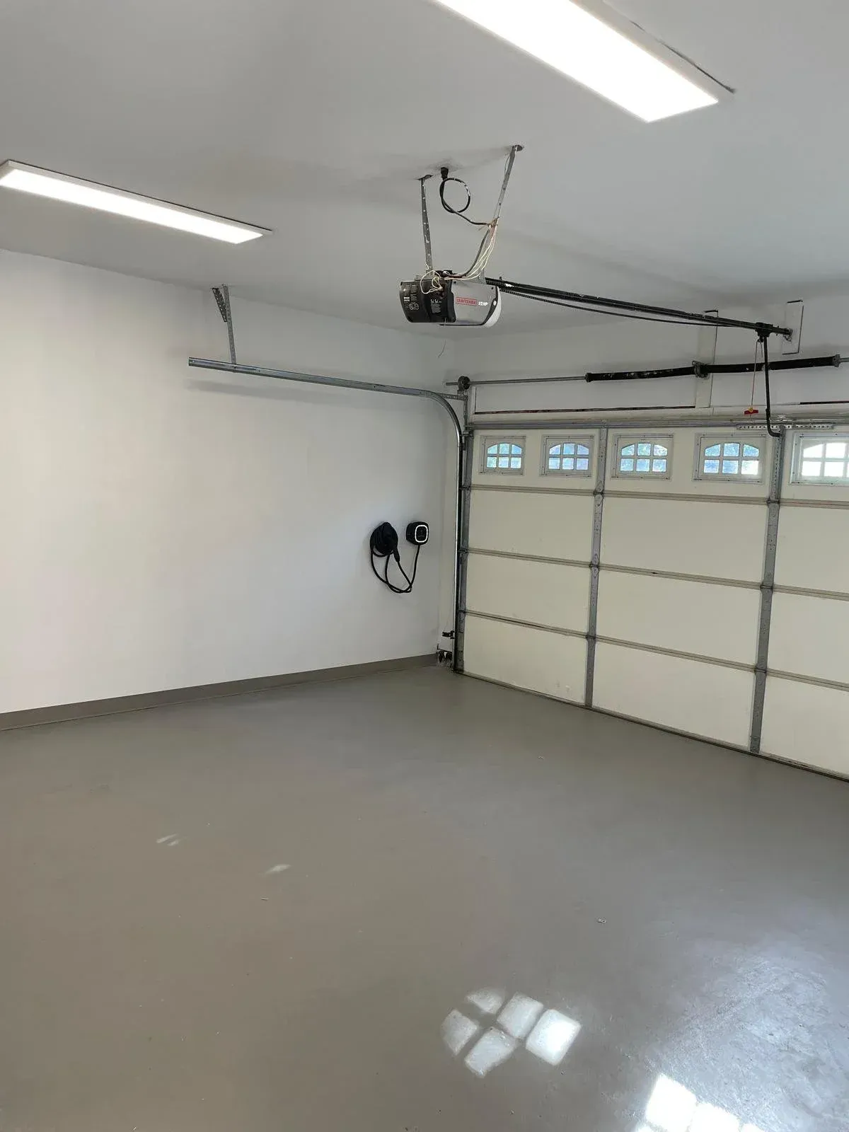 Interior of the fully insulated double garage at 110 Holliday Dr equipped with an EV charging station.
