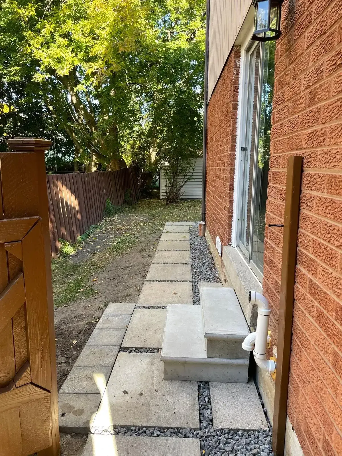 Stone walkway along the side of the house at 110 Holliday Dr leading to the backyard.