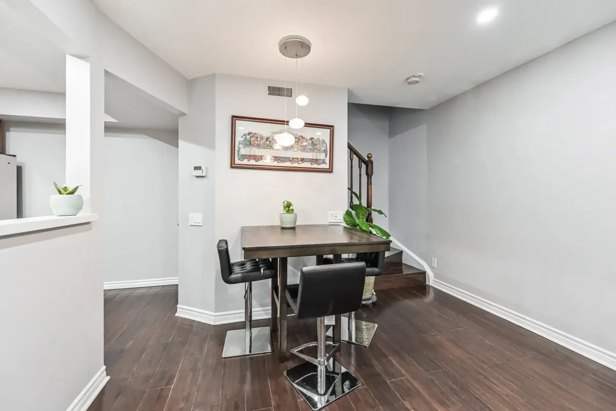 Dedicated dining room with modern lighting and dark wood accents at 900 Steeles Ave W #112.