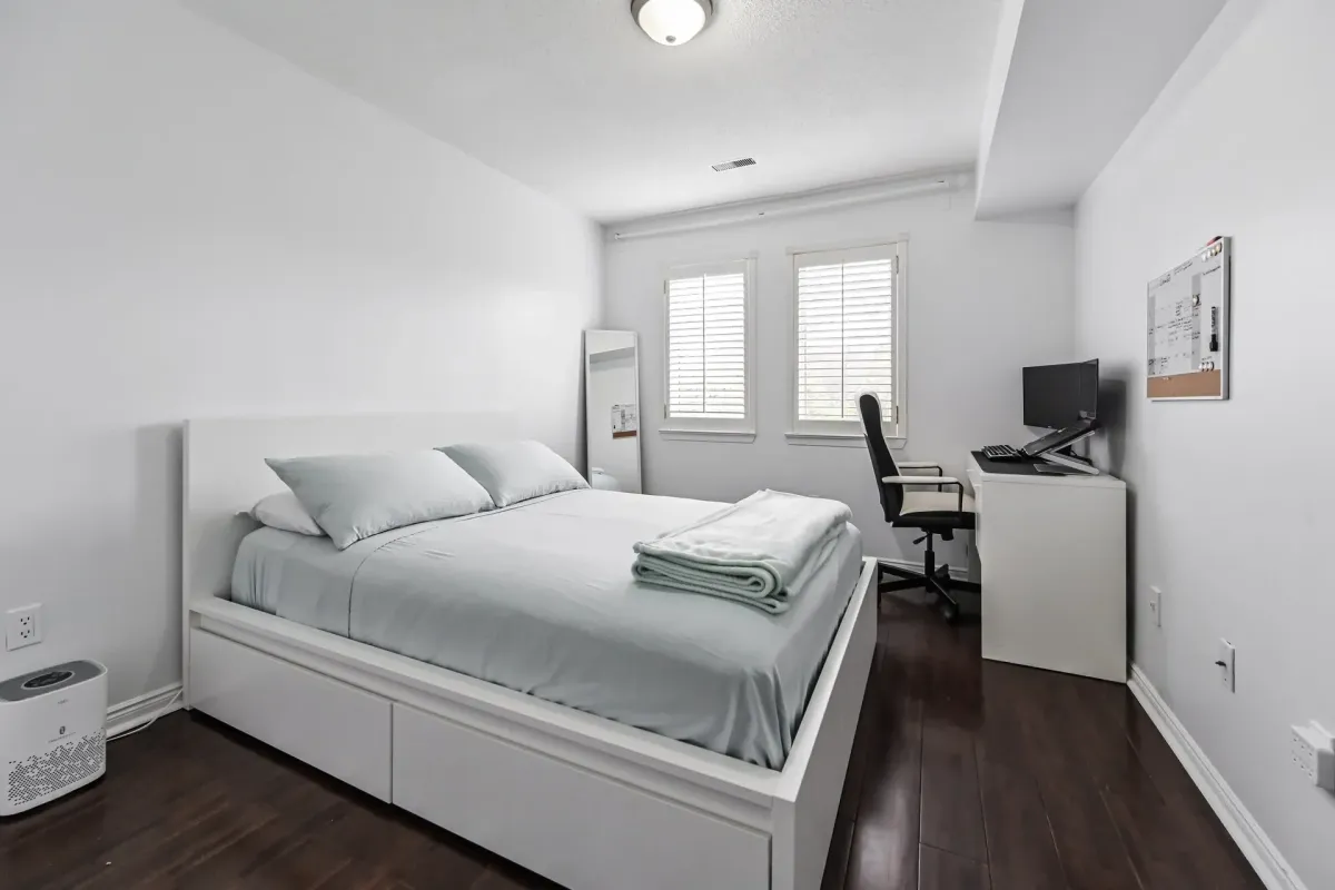 Bright secondary bedroom with a desk and large window at 900 Steeles Ave W #112.