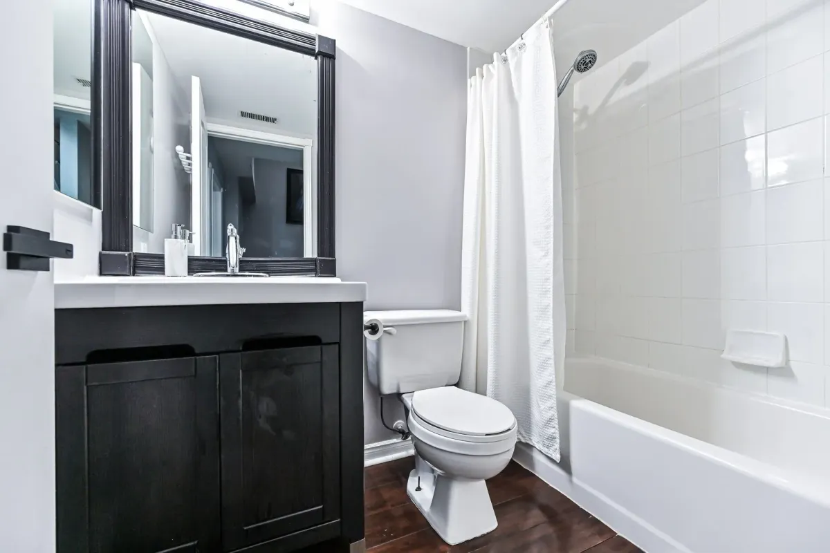 3-piece bathroom with dark wood vanity and bathtub at 900 Steeles Ave W #112.