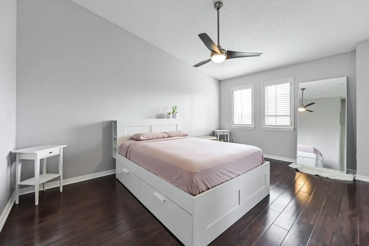 Large primary bedroom with high ceilings and white bed frame at 900 Steeles Ave W #112.