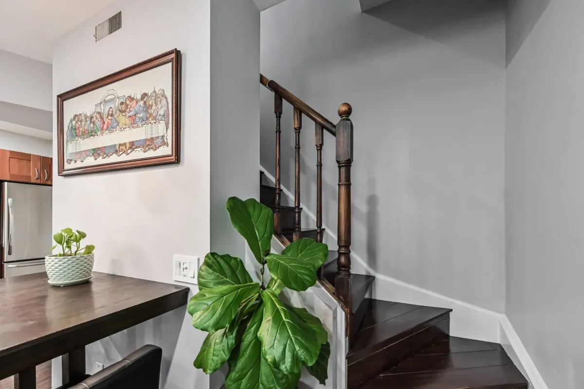 Dark wood staircase and landing area inside the 3-bedroom home at 900 Steeles Ave W #112.