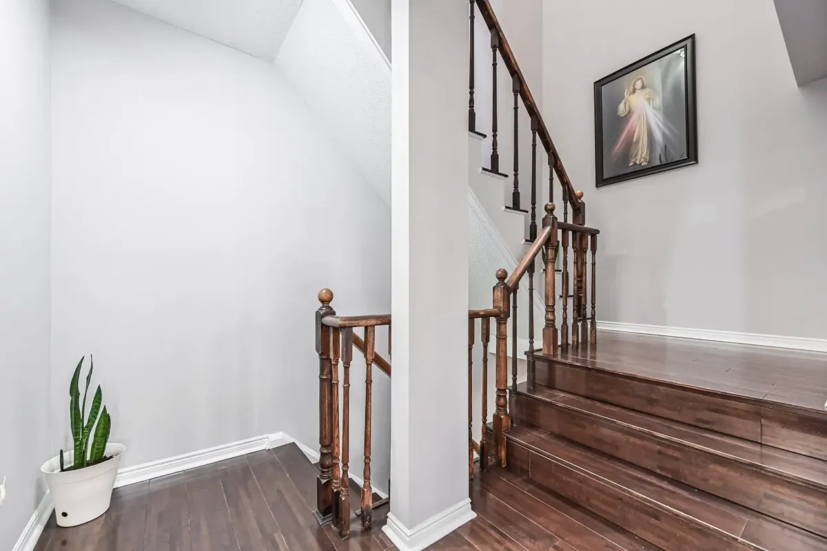 Second-floor landing with wood railings and neutral gray walls at 900 Steeles Ave W #112.