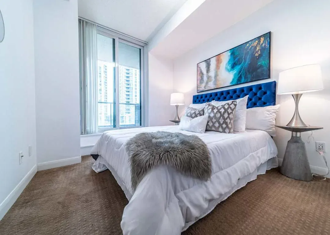 Primary bedroom at 235 Sherway Gardens Rd #401 featuring plush carpeting and a blue velvet headboard.