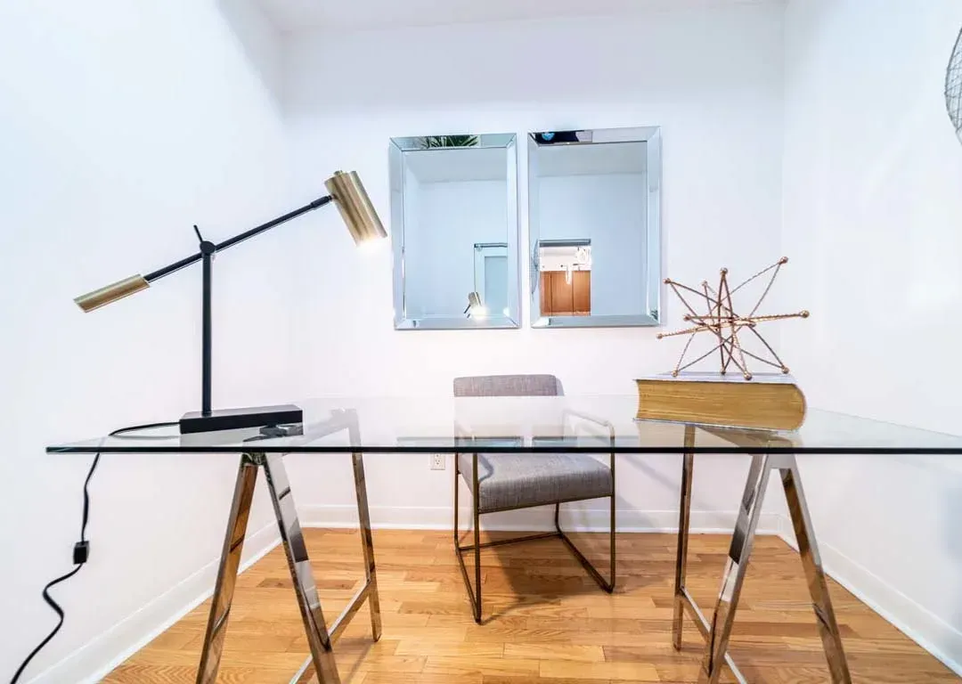 Dedicated home office/den at 235 Sherway Gardens Rd #401 with a glass desk and minimalist design.