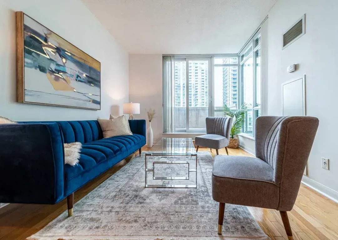 View from the blue velvet sofa in 235 Sherway Gardens Rd #401 toward the floor-to-ceiling windows and terrace access.