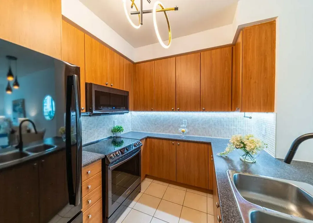 Gourmet kitchen at 235 Sherway Gardens Rd #401 featuring warm wood cabinetry and integrated appliances.