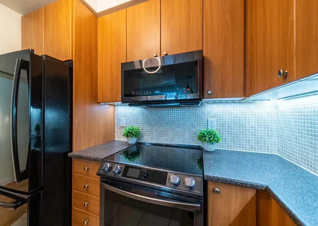 Kitchen workspace at 235 Sherway Gardens Rd #401 with a modern glass cooktop and under-cabinet lighting.