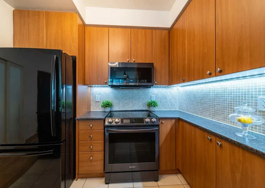 Wide-angle view of the kitchen at 235 Sherway Gardens Rd #401, including the stainless steel microwave and oven.