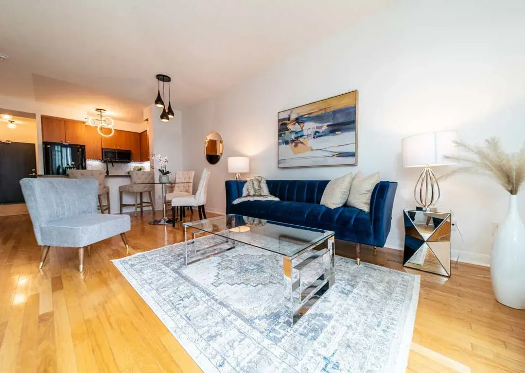 Open-concept living room at 235 Sherway Gardens Rd #401 featuring a vibrant blue velvet sofa and hardwood floors.