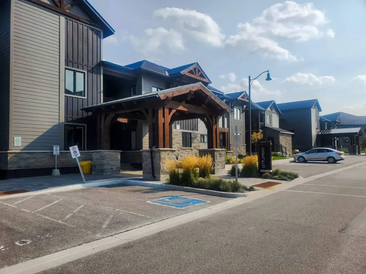 Front exterior and main entrance of the chalet-inspired condo building at 11 Beausoleil #105.