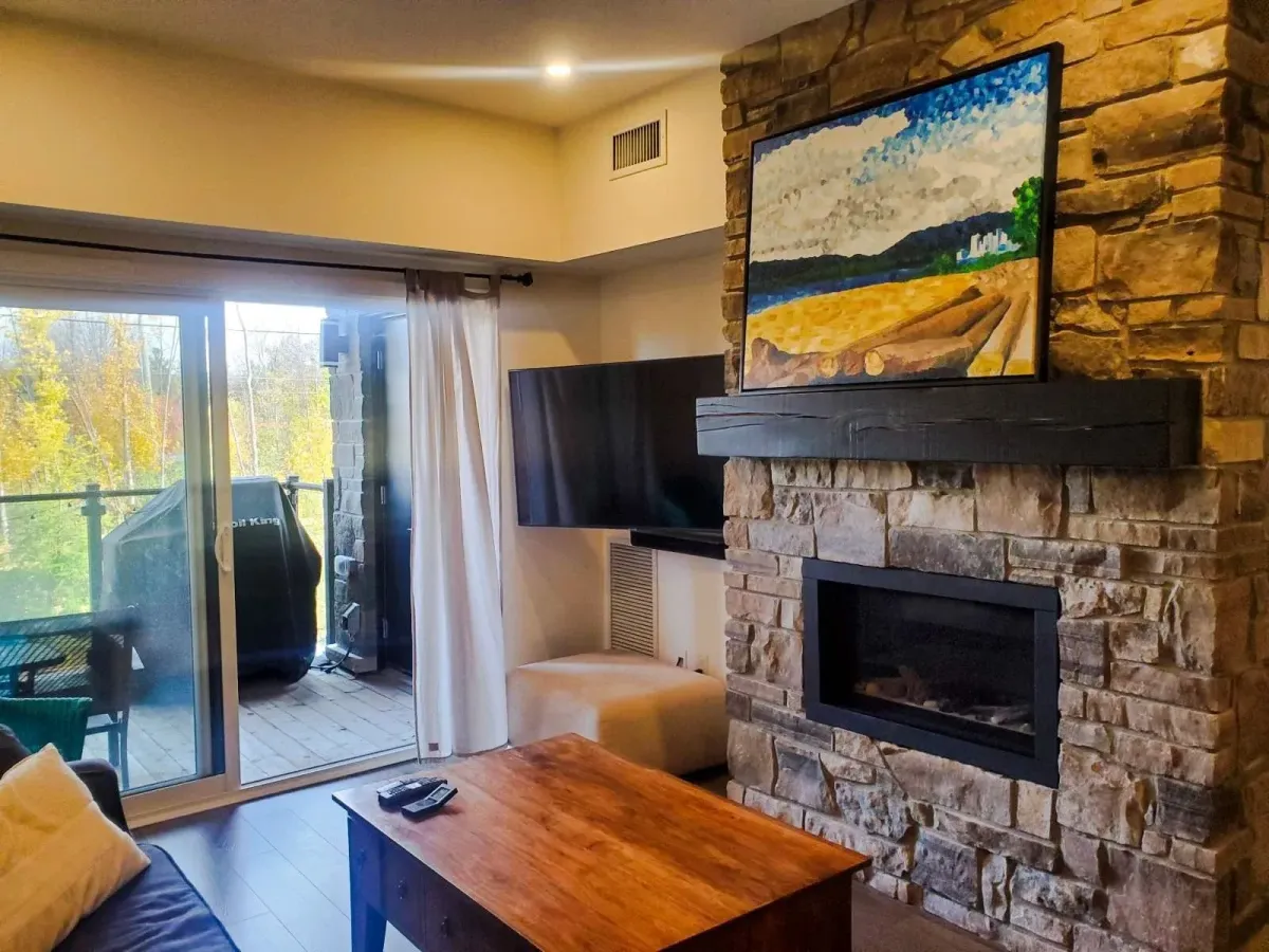 Sun-filled living room at 11 Beausoleil #105 with large windows and a walk-out to the private balcony.