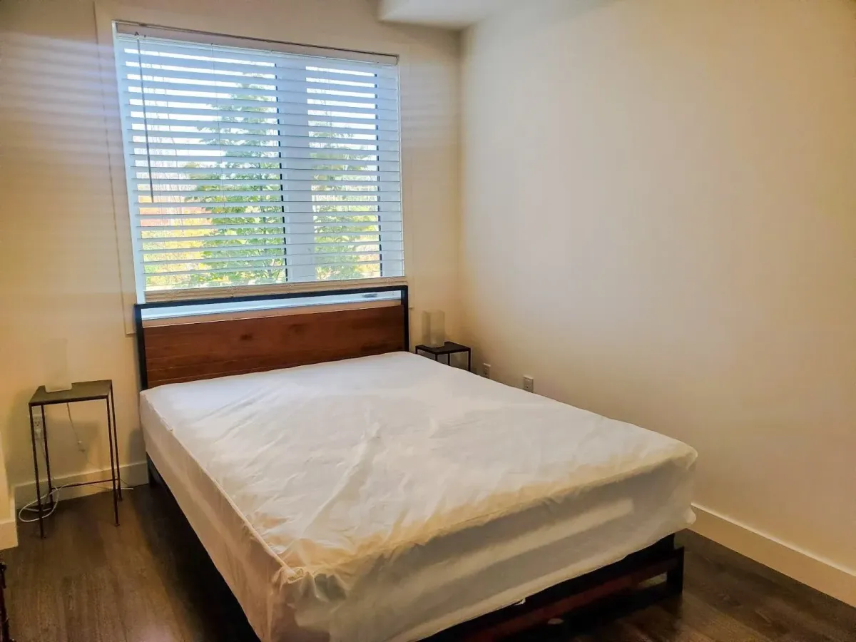 Primary bedroom at 11 Beausoleil #105 featuring a rustic wood headboard and neutral décor.