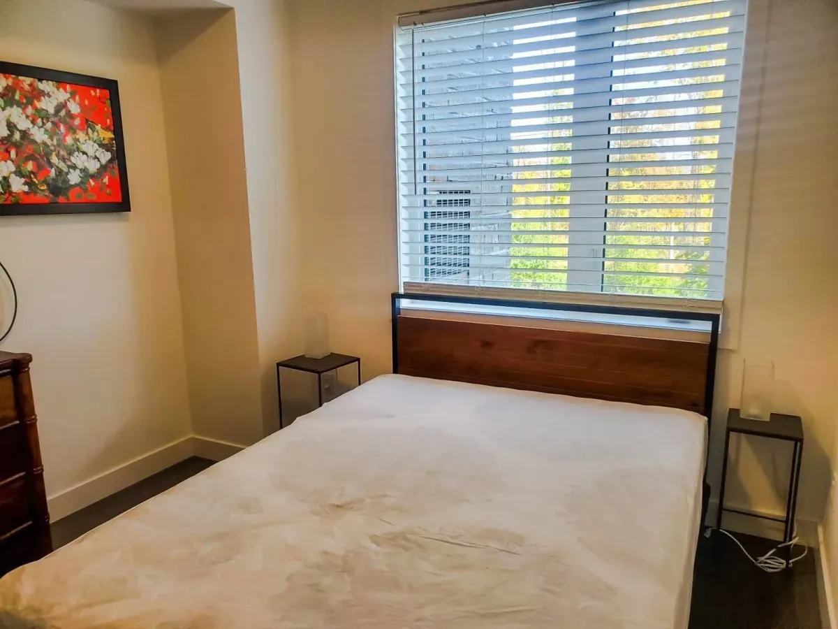 Bright master suite at 11 Beausoleil #105 with plush bedding and large windows overlooking the grounds.